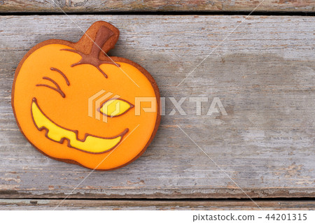 Halloween gingerbread cookie on wooden background. 44201315