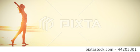 Side view of carefree woman with arms outstretched at beach 44203301