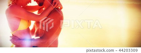 Side view of young couple embracing at beach Side view of young couple embracing at beach 44203309