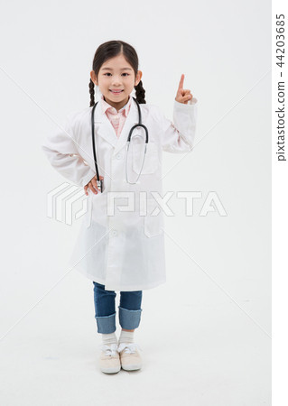 Boy dressed as doctor in white uniform and wearing stethoscope