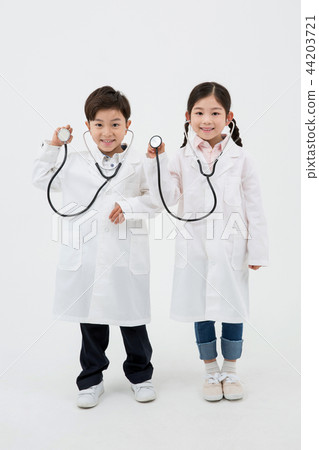 Children education. Young boy and girl wearing doctor uniform with stethoscope in white background 182 Children education. Young boy and girl wearing doctor uniform with stethoscope in white background 182 44203721