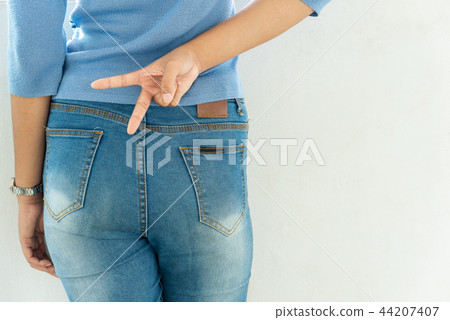 Young slim woman holds two fingers, victory sign. 44207407