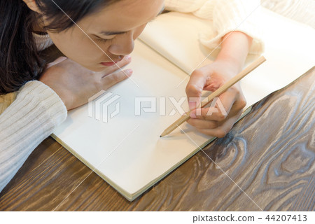 Woman hands with pen writing on notebook 44207413