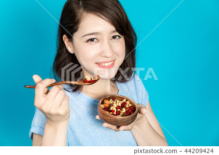A woman eating mixed nuts A woman eating mixed nuts 44209424