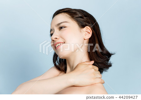 A woman rubbing her shoulder 44209427