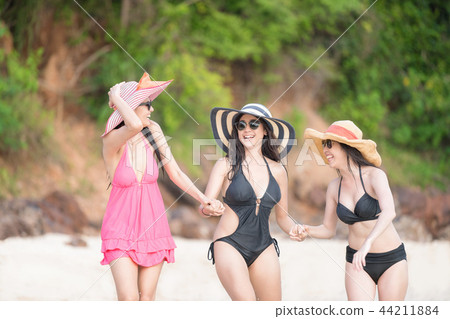 Happy girls gang are walking together on the beach 44211884