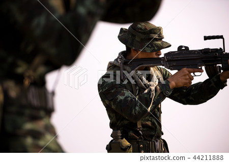 Soldiers patrolling across the deep forest area. Soldiers patrolling across the deep forest area. 44211888