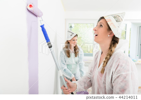 Female worker painting the wall 44214011