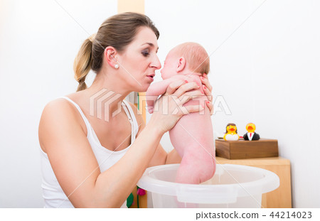 Mother holding baby in the bucket Mother holding baby in the bucket 44214023