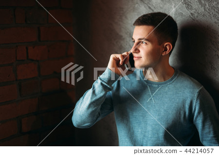 Man with phone in a cafe stand opposite the window. talking on the phone Man with phone in a cafe stand opposite the window. talking on the phone 44214057