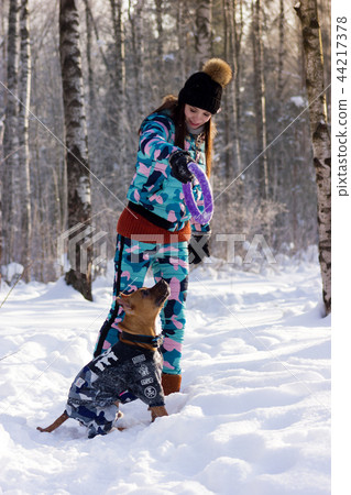 Adorable girl with her dog walks in park 44217378