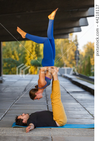Young man and woman practicing acro yoga on street Young man and woman practicing acro yoga on street 44218117