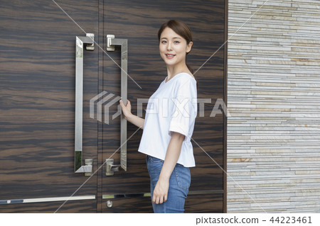 A woman in front of the entrance door A woman in front of the entrance door 44223461