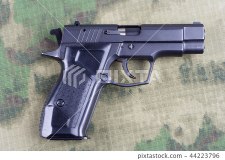 modern automatic pistol on camouflage background 44223796