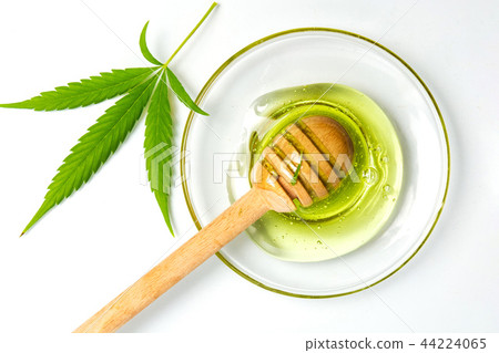 Cannabis honey and a dipper spoon isolated Cannabis honey and a dipper spoon isolated 44224065