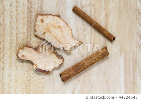 Cinnamon stick and dried ginger on wooden desk 44224545