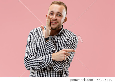 The young man whispering a secret behind her hand over pink background The young man whispering a secret behind her hand over pink background 44225449