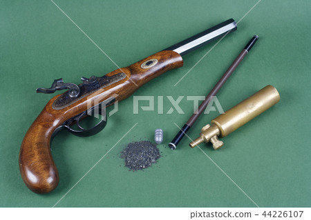 pistol with an accessory on green background 44226107