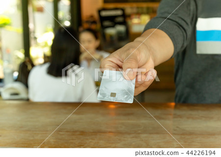 Customer paying through credit card at coffee shop 44226194