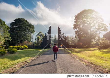 Man walking into bali ancient gate with sunlight 44226694