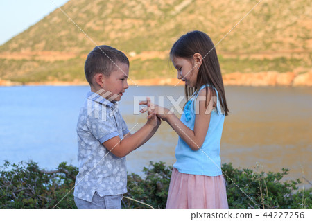 Girl and boy together outdoors. small brother playing with older sister 44227256