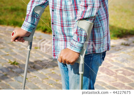 Man with crutches at outdoor Man with crutches at outdoor 44227675