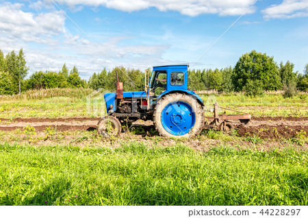 Agricultural tractor working at the potato field Agricultural tractor working at the potato field 44228297