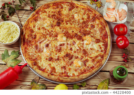Delicious seafood pizza served on wooden table. Delicious seafood pizza served on wooden table. 44228400