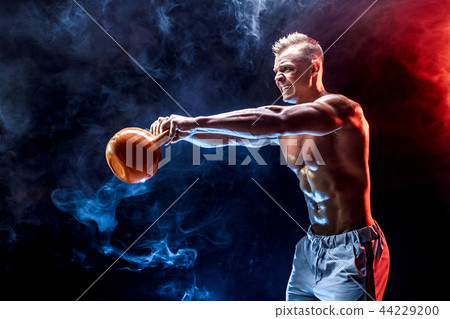 Concentrated muscular man doing exercise with kettlebell Concentrated muscular man doing exercise with kettlebell 44229200