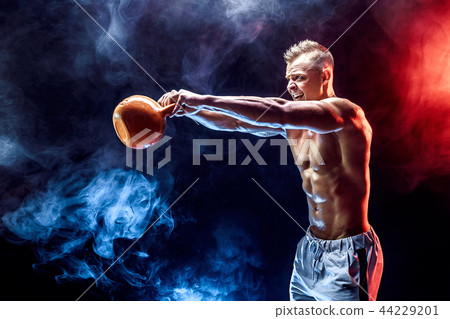 Concentrated muscular man doing exercise with kettlebell Concentrated muscular man doing exercise with kettlebell 44229201