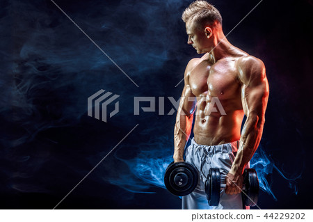 Topless man exercising biceps with dumbbells in studio Topless man exercising biceps with dumbbells in studio 44229202