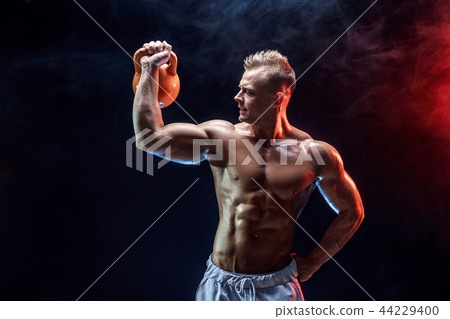Concentrated muscular man doing exercise with kettlebell Concentrated muscular man doing exercise with kettlebell 44229400