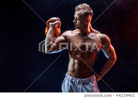 Concentrated muscular man doing exercise with kettlebell Concentrated muscular man doing exercise with kettlebell 44229401