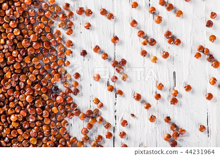 Red quinoa seeds on white wooden table. 44231964