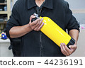 Unidentified people holding yellow oxygen tank. 44236191