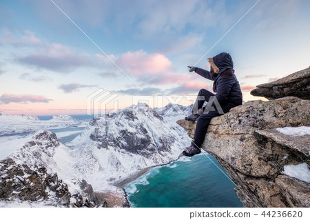 Mountaineer sitting on rock at the peak mountain 44236620