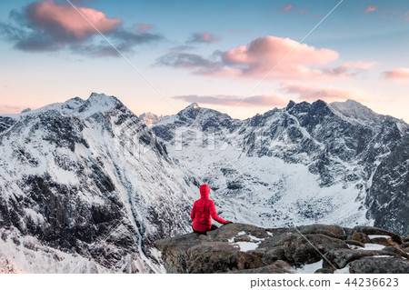 Red mountaineer relaxing on rock 44236623