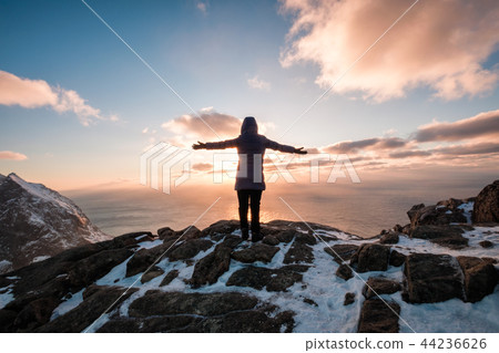 Woman climbing with raised hand on mountain 44236626