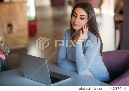 Beautiful brunette business woman use phone in a cafe with laptop Beautiful brunette business woman use phone in a cafe with laptop 44237044