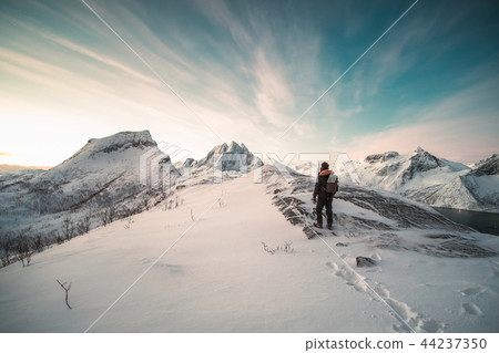 Mountaineer standing on top of snowy mountain Mountaineer standing on top of snowy mountain 44237350