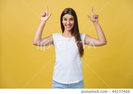 Profile of a woman pointing on copy space for an advertisement isolated on a yellow background 44237488