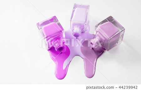 Three open bottles of nail polish spilled on a white background. 44239942