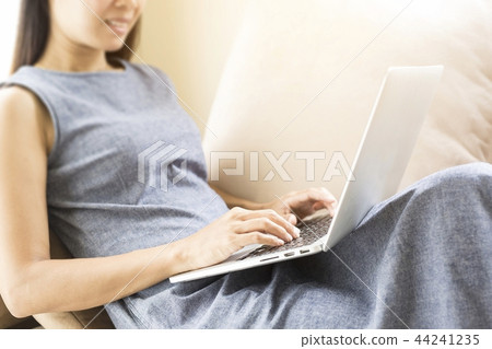 Woman sitting on the sofa.She is working. Woman sitting on the sofa.She is working. 44241235