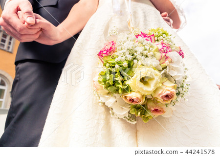 Bride and bridegroom holding each other's hand 44241578