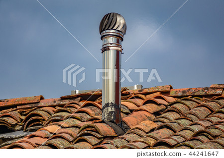 Aluminum chimney over old red tile roof Aluminum chimney over old red tile roof 44241647
