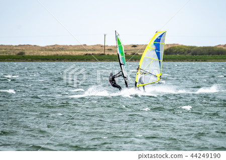 Man windsurfing close to the town of Caernarfon in Wales - United Kingdom Man windsurfing close to the town of Caernarfon in Wales - United Kingdom 44249190