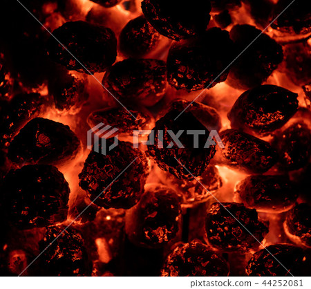 Flaming hot charcoal briquettes in detail 44252081