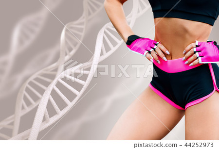 Young woman with athletic body standing among DNA chains. Young woman with athletic body standing among DNA chains. 44252973