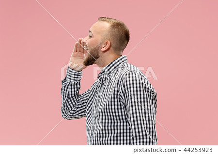 Isolated on pink young casual man shouting at studio 44253923