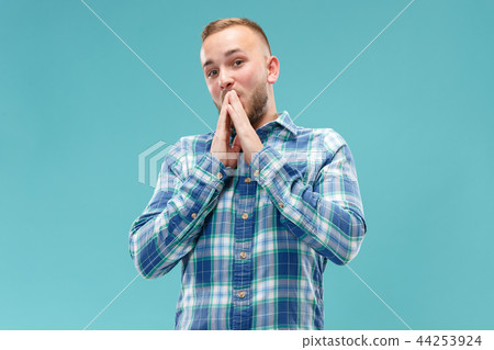 The young attractive man looking suprised isolated on blue 44253924
